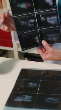 Genç bayan doktor ultrasonu inceliyor.