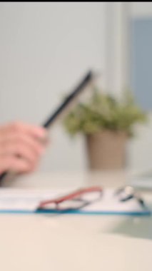 Doktor kadın tablet bilgisayarla çalışıyor.