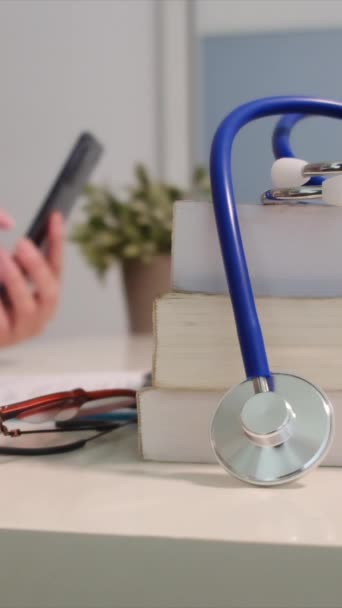 Close View Stethoscope Books Table Female Doctor Using Smartphone Background — Stock Video