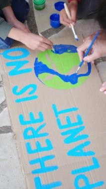 İklim değişikliği kavramı. Protesto üzerine pankart çizen insanlar  