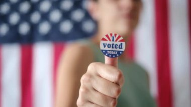 Bugün birlikte oy verdiğim kadın ABD bayrağının arka planında. 