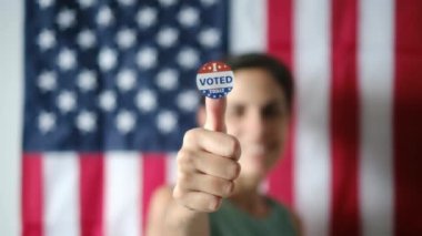 Bugün birlikte oy verdiğim kadın ABD bayrağının arka planında. 