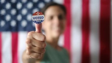 Bugün birlikte oy verdiğim kadın ABD bayrağının arka planında. 