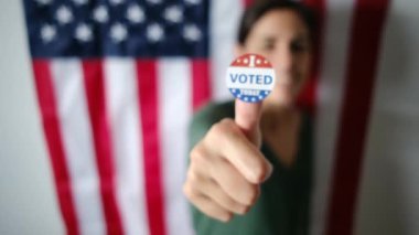 Bugün birlikte oy verdiğim kadın ABD bayrağının arka planında. 