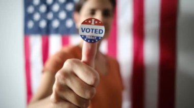 Bugün birlikte oy verdiğim kadın ABD bayrağının arka planında. 