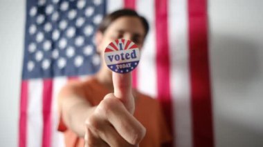 Bugün birlikte oy verdiğim kadın ABD bayrağının arka planında. 