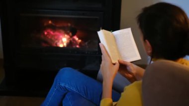 Kadın okuma kitabı şömine yakın