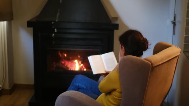 与本书靠近壁炉旁的女人 — 图库视频影像