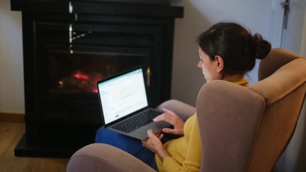 Жінка Використовує Ноутбук Біля Каміна — стокове відео