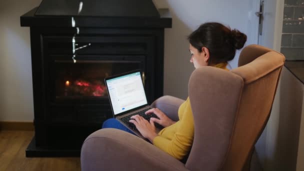 Жінка Використовує Ноутбук Біля Каміна — стокове відео