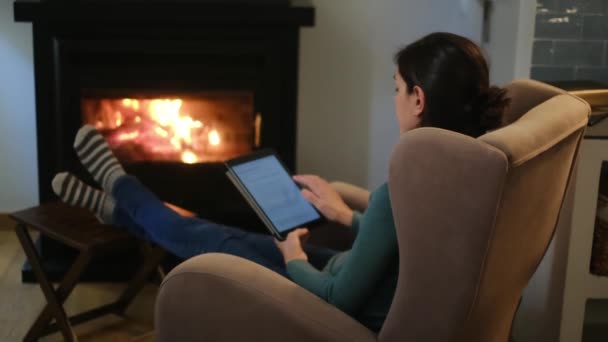在壁炉附近使用平板电脑的妇女 — 图库视频影像