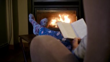 Kadın okuma kitabı şömine yakın