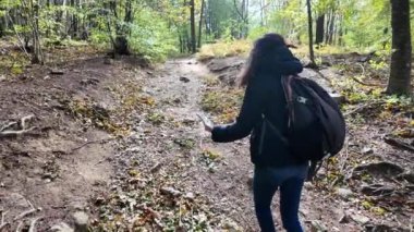 Ormanda akıllı telefonlu bir kadın doğa yürüyüşçüsü. 