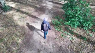 Kadın yürüyüşçü ormanda, doğa yolunda yürüyor.