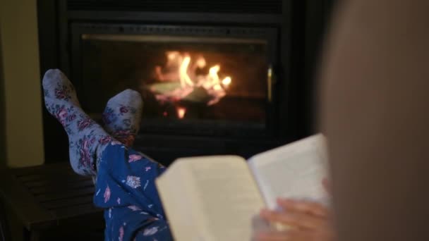 Mujer Leyendo Libro Junto Chimenea — Vídeo de stock