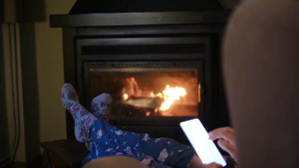 Sıcak Çoraplı Şöminenin Yanında Akıllı Telefonu Olan Bir Kadın — Stok video