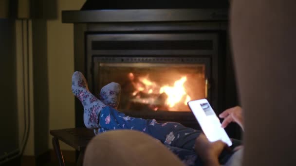 Kobieta Ciepłych Skarpetkach Smartfonem Przy Kominku — Wideo stockowe