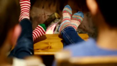 Çocuklar şöminenin yanında oturuyor.