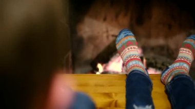 Çocuklar şöminenin yanında oturuyor.