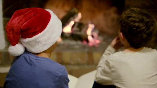 Παιδιά Γιορτάζουν Χριστούγεννα Δίπλα Στο Τζάκι Αγόρι Που Γράφει Γράμμα — Αρχείο Βίντεο