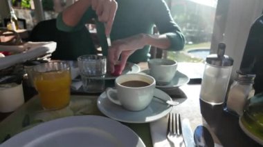 Sabahları kahvaltı yapan bir kadın.