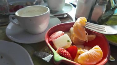 Çatalla meyve alan kişi