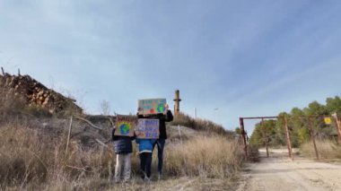 İklim değişikliği kavramı. Annesi olan oğlanlar pankartlarla protesto ediyor