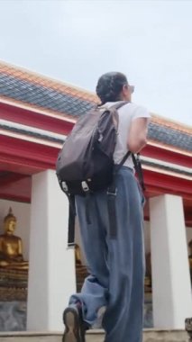 Sırt çantalı bir kadın güneydoğu Asya 'da Budist kültüründe yürüyor.