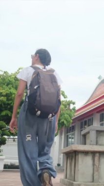 Sırt çantalı kadın gezginin arkasında Güneydoğu Asya 'daki Budist kültürünün cazibe mimari geçidinde yürüyor.