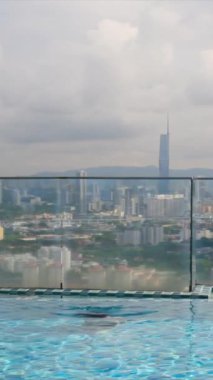 şehir silueti üzerinde sonsuz havuzda yüzen seyahat eden bir kadın. 