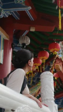 Sırt çantalı bir kadın Budist tapınağında yürüyor.