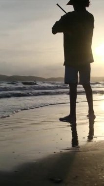 Çocuk denizde sahilde oynuyor.