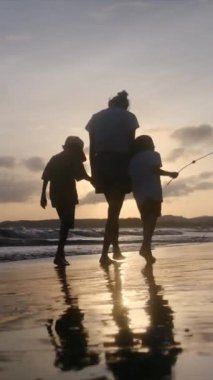 Aile bağının yürek ısıtan özünü bir annenin ve oğullarının sakin bir sahilde büyüleyici bir gün batımının arka planında el ele tutuşmaları gibi yaşayın.