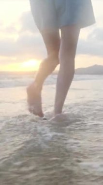  Yaz tatilinde ya da tatilde deniz ya da okyanus kenarında koşan kadın bacakları. Sahilde, doğada ve özgürlükte bir kadın tek başına akıntıda, gelgitte ya da dalgalarda yürür.