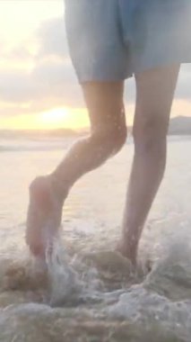  Yaz tatilinde ya da tatilde deniz ya da okyanus kenarında koşan kadın bacakları. Sahilde, doğada ve özgürlükte bir kadın tek başına akıntıda, gelgitte ya da dalgalarda yürür.