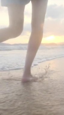  Yaz tatilinde ya da tatilde deniz ya da okyanus kenarında koşan kadın bacakları. Sahilde, doğada ve özgürlükte bir kadın tek başına akıntıda, gelgitte ya da dalgalarda yürür.