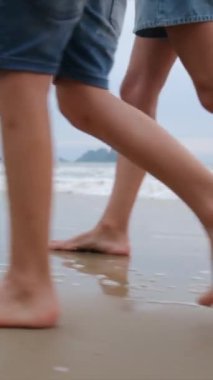 mother with child  walking barefoot on the beach