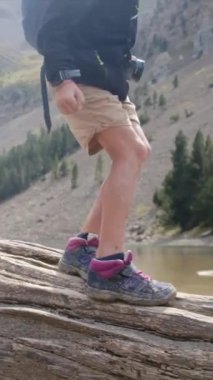 Sırt çantalı çocuk dağ nehrinde yürüyor. 