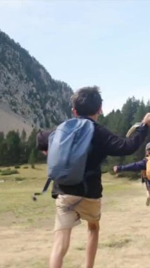 Genç yürüyüş meraklılarıyla güneşli mevsimlerin tadını çıkarın. Oğullarıyla dağlarda yürüyüş yapan bir kadın. 