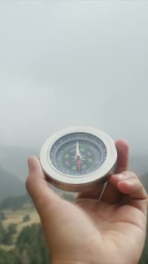Dağlarda pusula tutan bir adam 