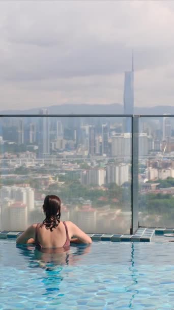 Şehir Silueti Üzerinde Sonsuz Havuzda Yüzen Seyahat Eden Bir Kadın — Stok video