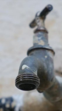 Lavabonun musluğundan bir damla su yavaş çekimde, musluğun yakınına düşer. Su yok, iklim değişikliği yok..