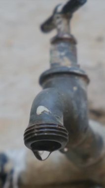 Lavabonun musluğundan bir damla su yavaş çekimde, musluğun yakınına düşer. Su yok, iklim değişikliği yok..
