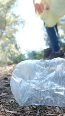 Kadın çevreyi korumak ve kirliliği azaltmak için ormandan çöp topluyor. Çöp toplama gönüllüsü takım çalışması 