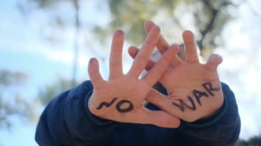 Avuçlarında savaş kelimeleri olmayan çocuk, yakın plan.