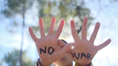 Avuçlarında savaş kelimeleri olmayan çocuk, yakın plan.