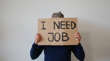 Dinozor maskesi takan bir işadamı üzerinde metin olan bir kart gösteriyor. 