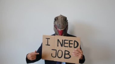 Dinozor maskesi takan bir işadamı üzerinde metin olan bir kart gösteriyor. 