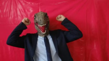 Dinozor maskeli bir iş adamı içeride yumruklarını gösteriyor.