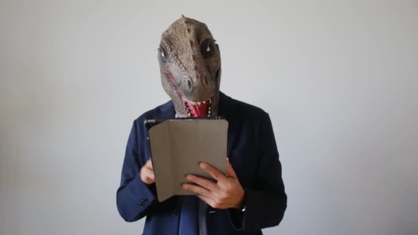 Επιχειρηματίας Μάσκα Δεινόσαυρος Κρατώντας Tablet Εσωτερικούς Χώρους — Αρχείο Βίντεο